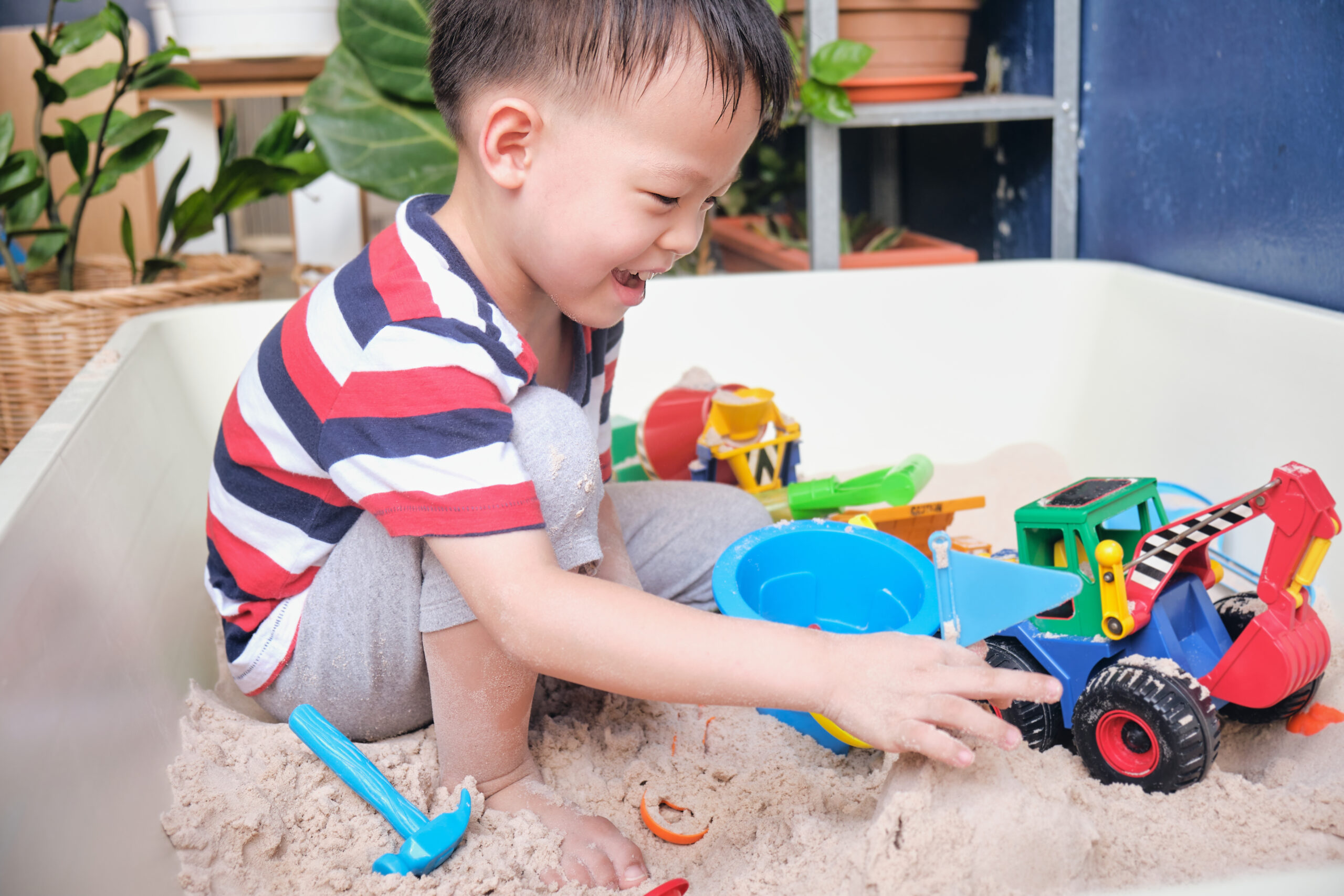 A kid playing happily with sand toys, building and exploring on their own—highlighting how the right toys encourage independent play, creativity, and focused fun with MyToyShop.
