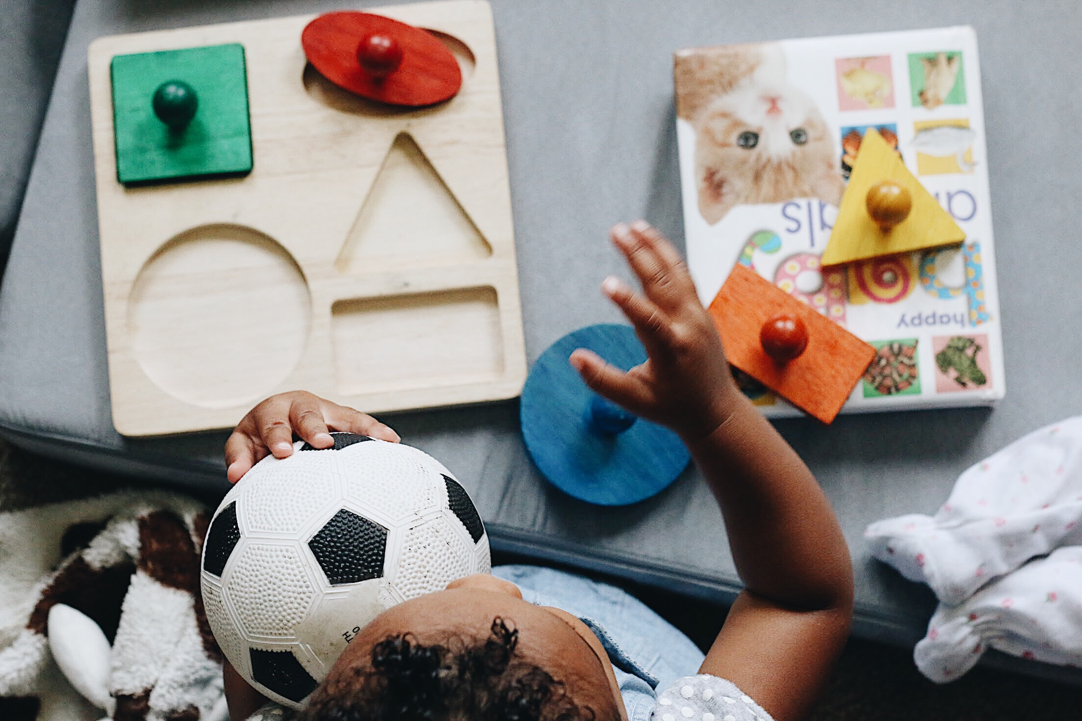 Child playing with a football alongside colorful educational toys and shape-sorting blocks, capturing the excitement of sports-themed play during World Cup seasons. This image highlights how football toys combine fun, learning, and collectability, making World Cup years the perfect time for kids and collectors to explore themed toys and games.