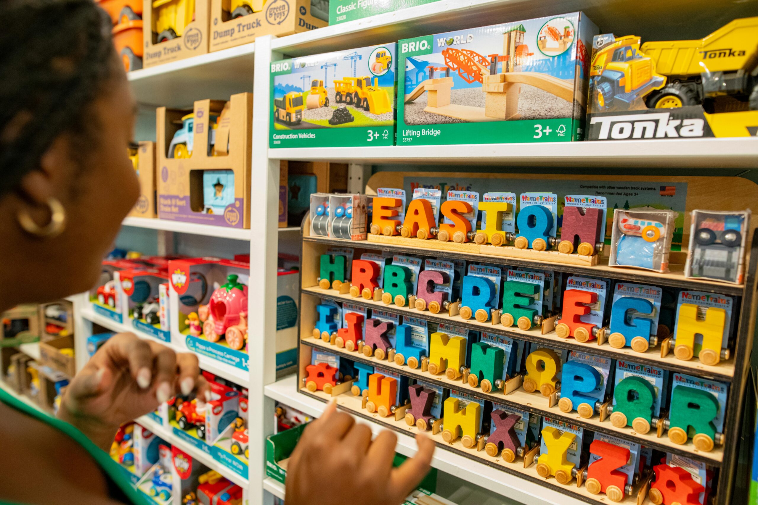 Child browsing educational toys and alphabet train sets at a toy shop in Singapore for kids.