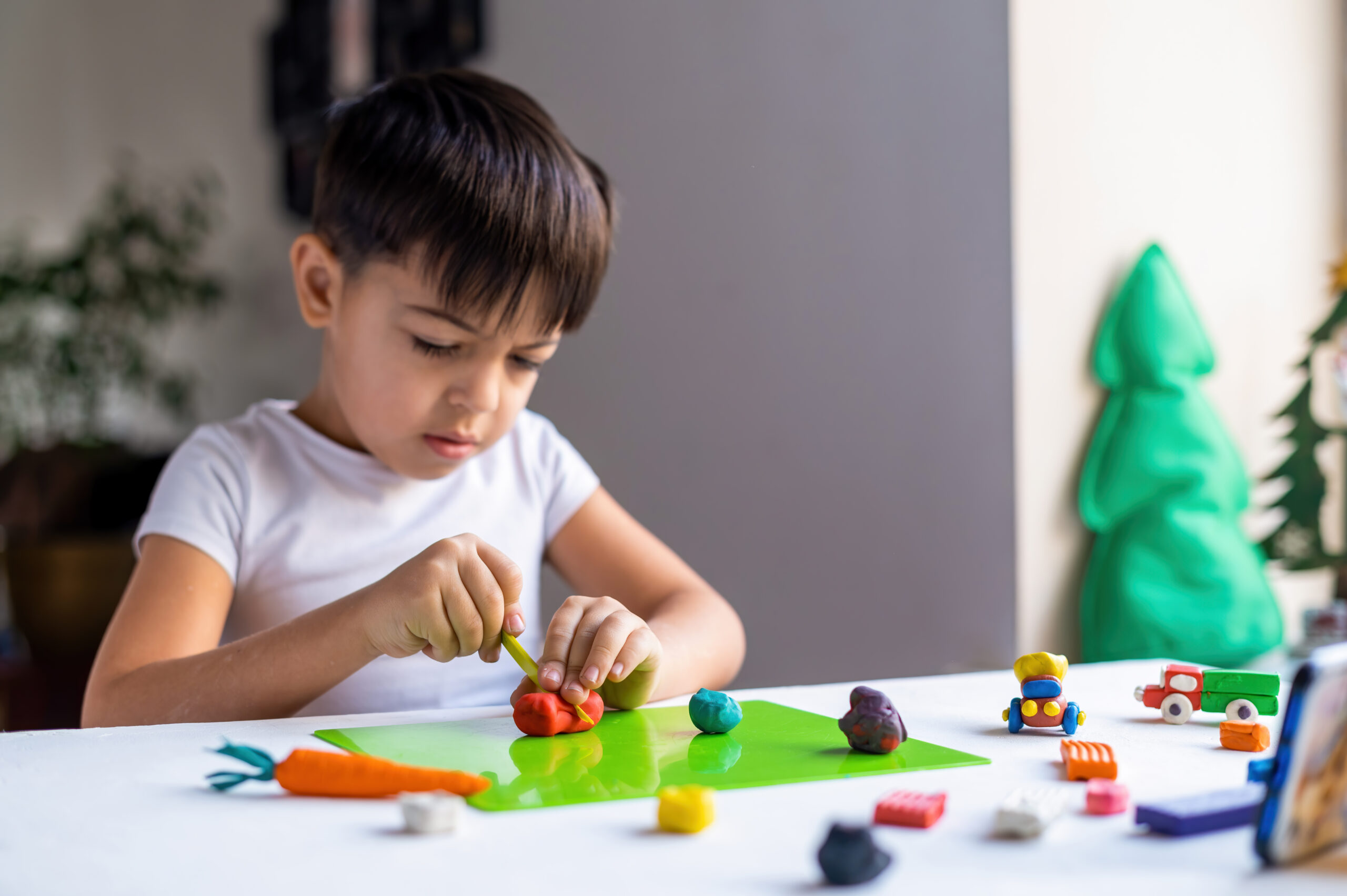 Child practising fine motor skills by threading colourful beads onto a string at home.